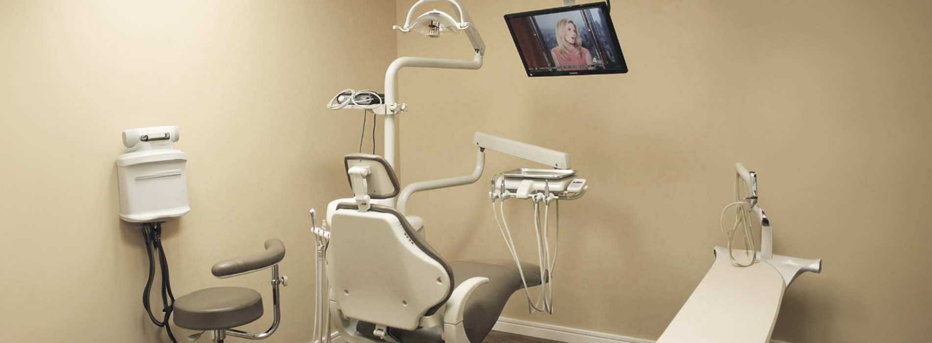 The image shows a modern dental clinic interior with various pieces of equipment, including a dental chair and an X-ray machine.